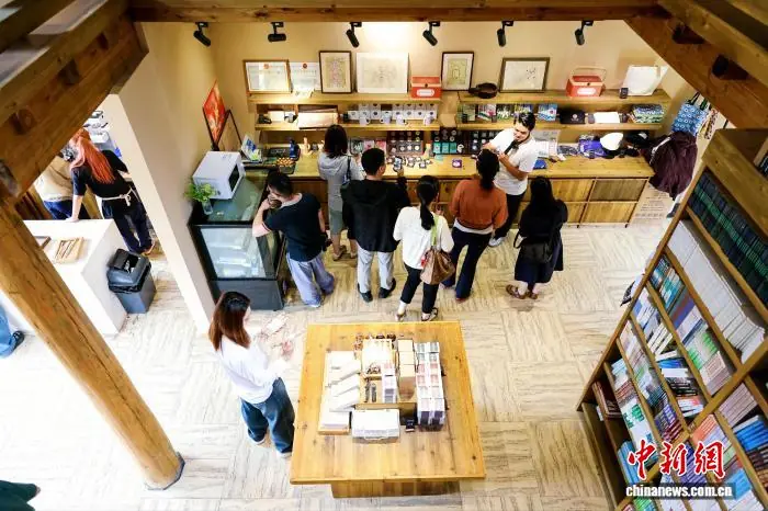 2026年6月，游客在贵州雷山县乌东苗寨的诸野书店参观并挑选文创产品。李峰 摄