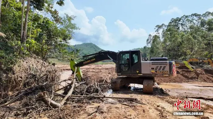 7月13日,孤岛<strong></strong>挖掘机疏通前往那旭村的救援记道路。俞靖 摄